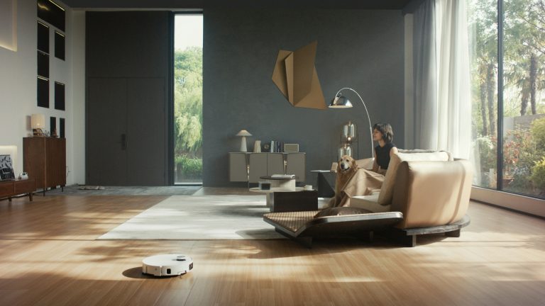 Saugroboter fährt durch ein helles, modernes Wohnzimmer mit Holzboden
